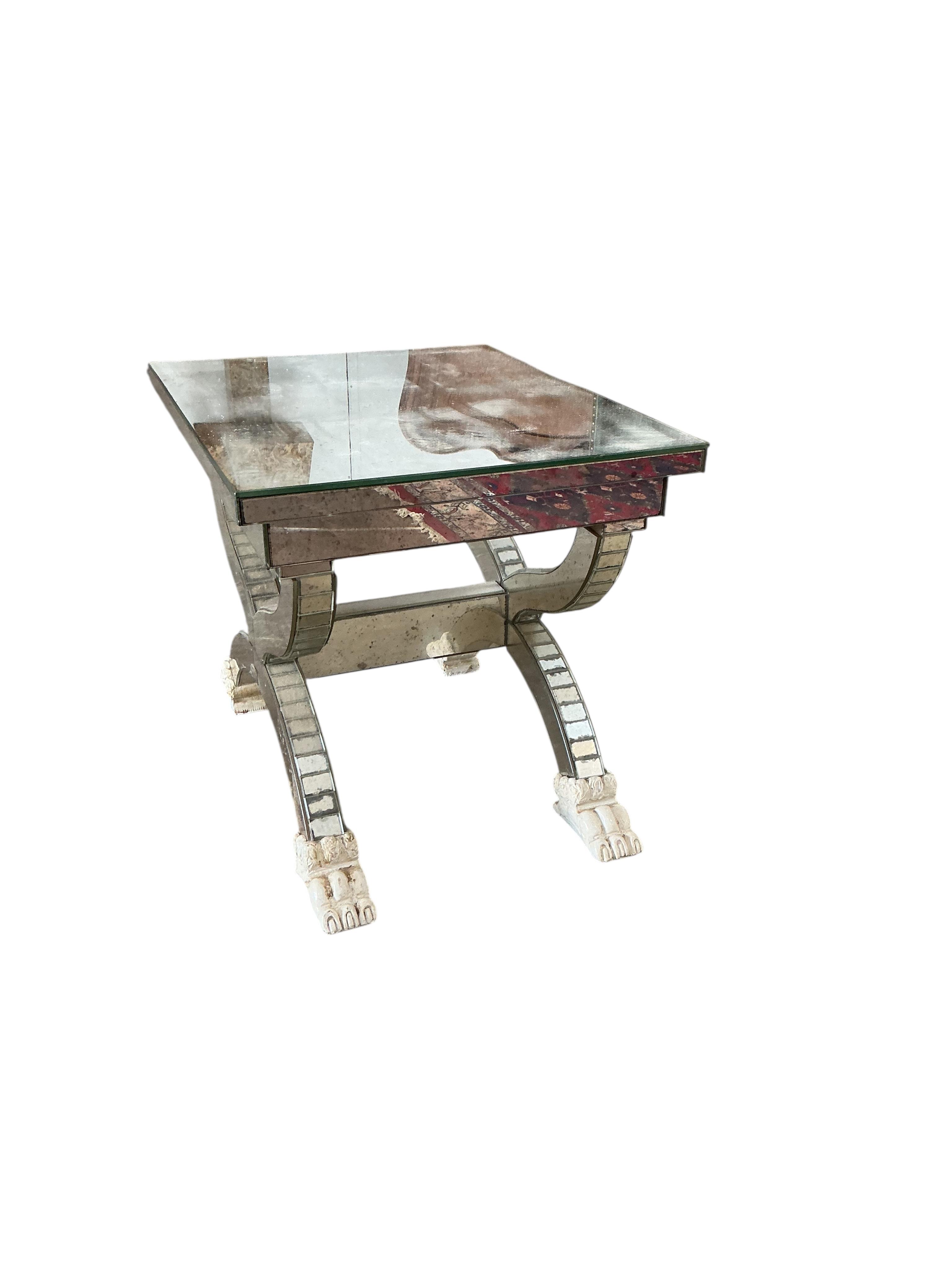 A mirror panelled X-framed lamp table, on four cream painted lion paw feet, width 56cm, depth 46cm, height 48cm